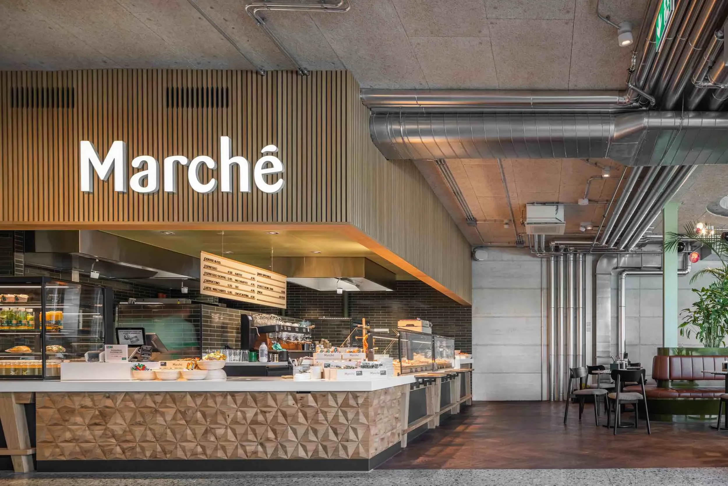 Marché Deitingen Süd - GALA DESIGN verwandelte Marché Deitingen in eine Verbindung von Geschichte und Moderne, die ikonische Architektur mit warmem, einladendem Design vereint.